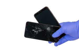 mao-enluvada-segura-um-smartphone-quebrado-com-uma-tela-do-telefone-movel-rachada-e-uma-nova-tela-do-telefone-movel-em-um-espaco-em-branco_262398-14